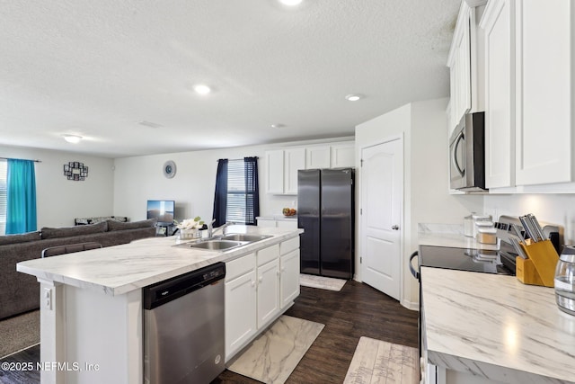 kitchen with white cabinetry, appliances with stainless steel finishes, open floor plan, and a sink