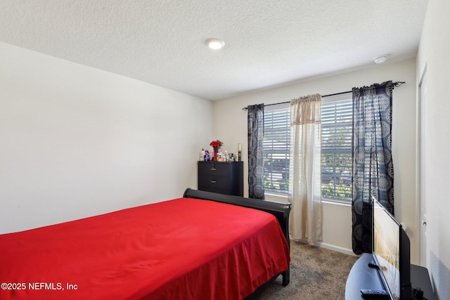 carpeted bedroom with a textured ceiling and baseboards