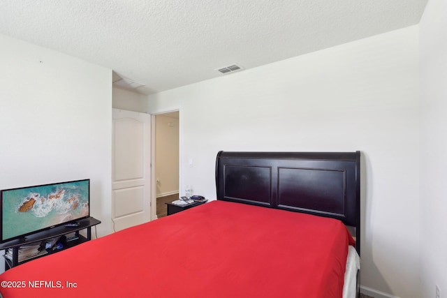 bedroom with a textured ceiling and visible vents