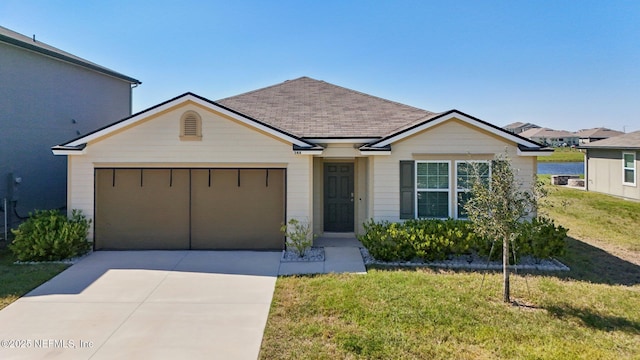 view of front facade featuring driveway, a shingled roof, a garage, and a front yard