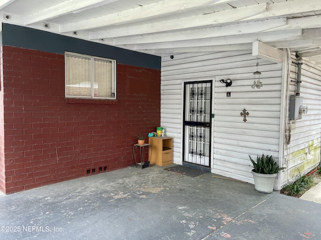 view of exterior entry featuring brick siding