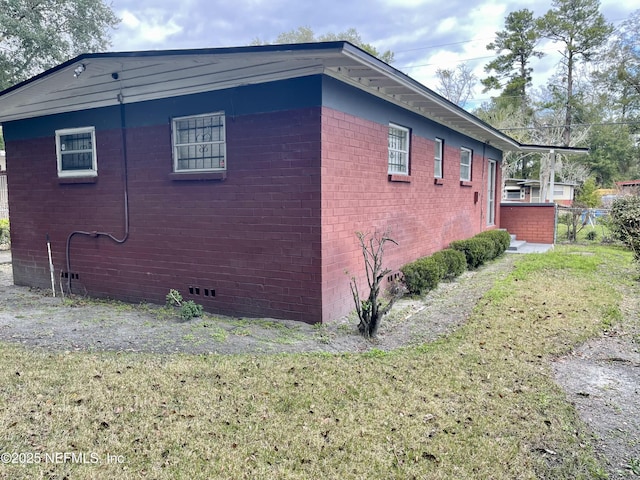 view of property exterior with crawl space and brick siding