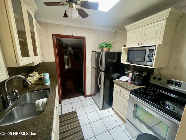 kitchen featuring stainless steel appliances, ornamental molding, a sink, and wallpapered walls