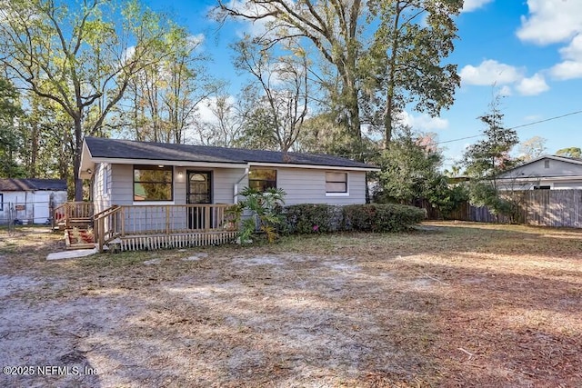 single story home with covered porch and fence