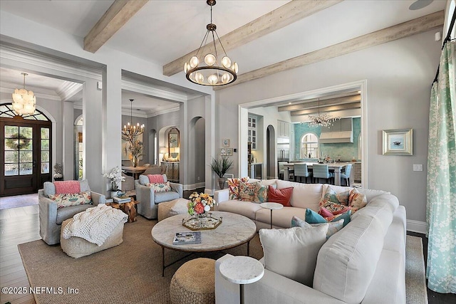 living area with a wealth of natural light, a chandelier, arched walkways, and beam ceiling