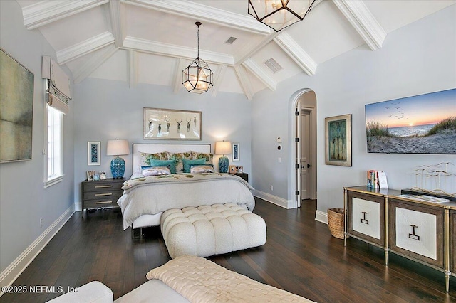 bedroom featuring arched walkways, wood-type flooring, visible vents, and baseboards