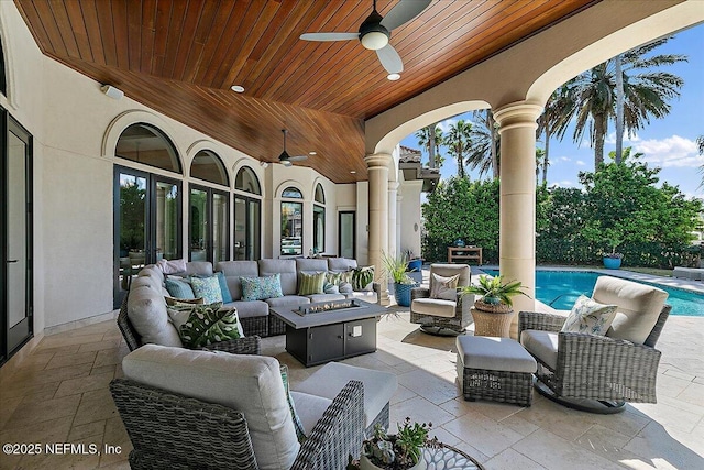 view of patio with a ceiling fan, an outdoor living space with a fire pit, and an outdoor pool