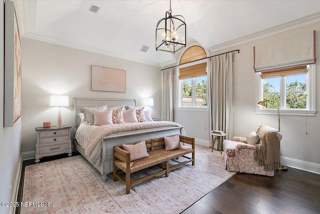 bedroom with ornamental molding, baseboards, visible vents, and hardwood / wood-style floors