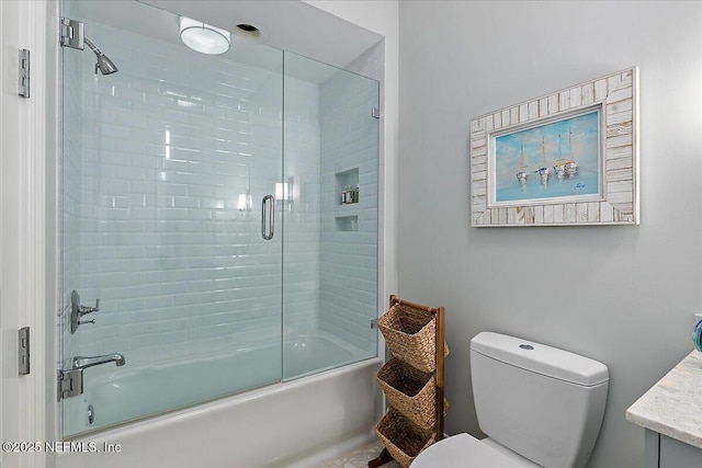 bathroom with bath / shower combo with glass door, vanity, and toilet