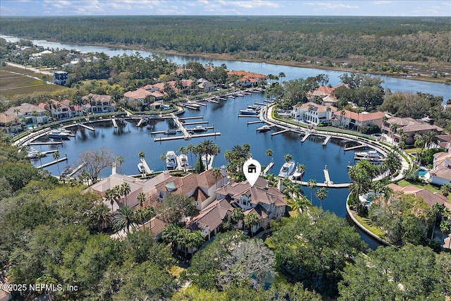 birds eye view of property featuring a water view, a wooded view, and a residential view