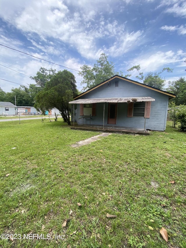 view of front of property featuring concrete block siding and a front lawn