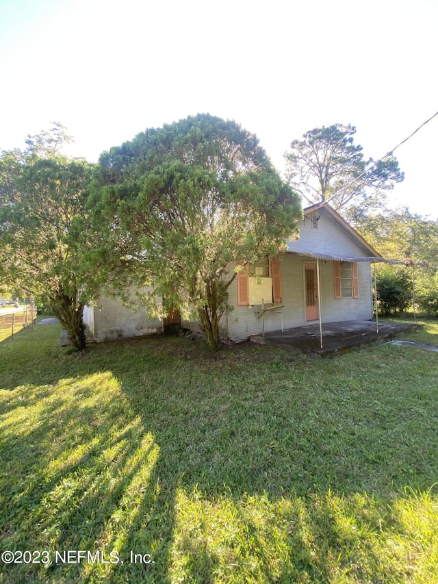 view of property exterior with a yard and a patio