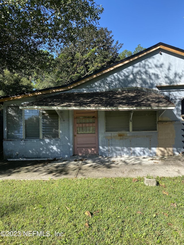 view of front of house with a garage, concrete block siding, and roof with shingles