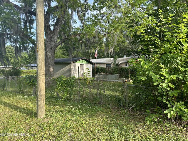 view of yard with an outbuilding and fence