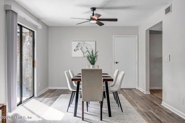 dining area featuring visible vents, plenty of natural light, a textured ceiling, and light wood finished floors