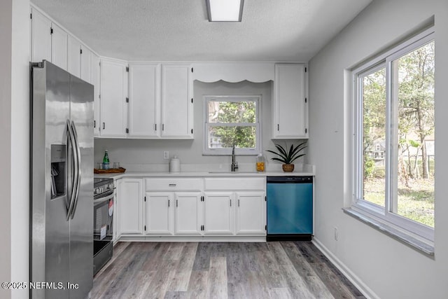 kitchen with stainless steel fridge with ice dispenser, light countertops, stove, a sink, and dishwashing machine