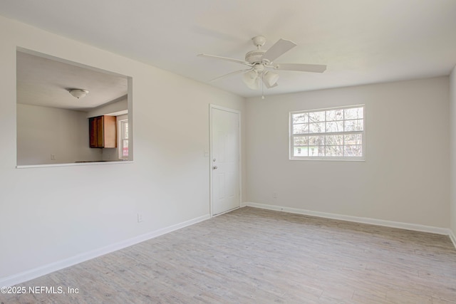 unfurnished room with baseboards, a ceiling fan, and light wood-style floors