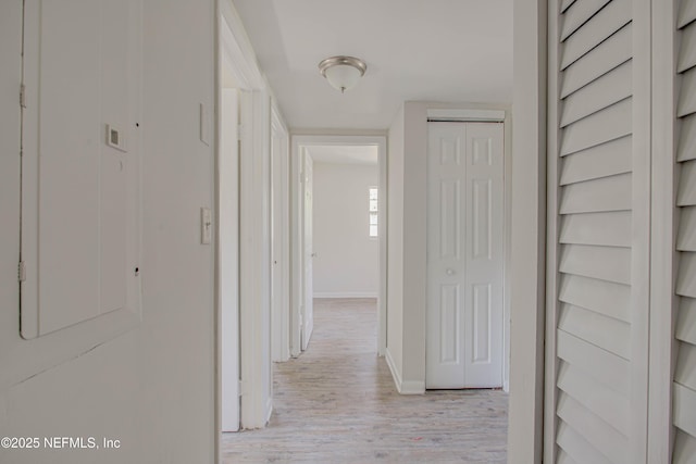 hallway with light wood finished floors and baseboards