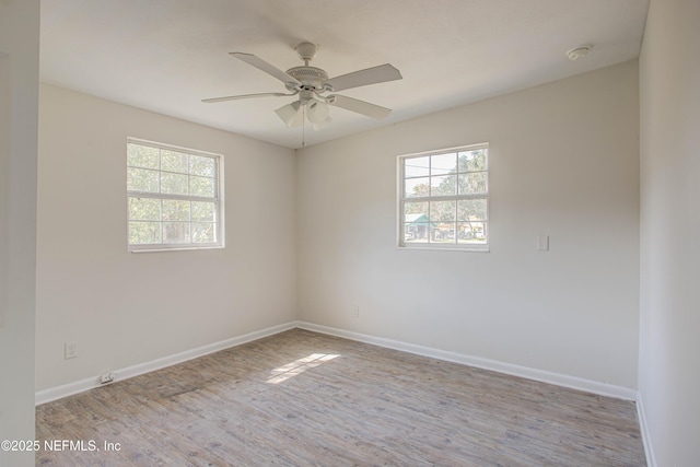 unfurnished room with ceiling fan, plenty of natural light, baseboards, and wood finished floors