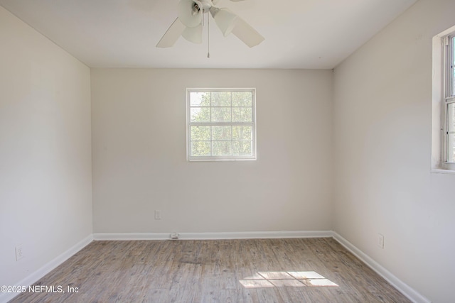 unfurnished room featuring a ceiling fan, baseboards, and wood finished floors