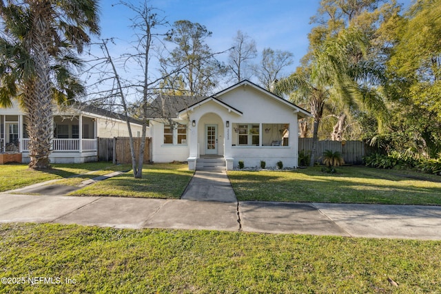 bungalow-style home with fence and a front yard