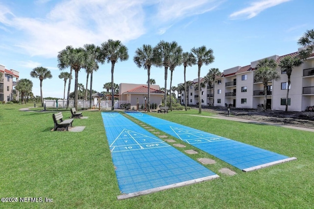 surrounding community with shuffleboard, a yard, and fence