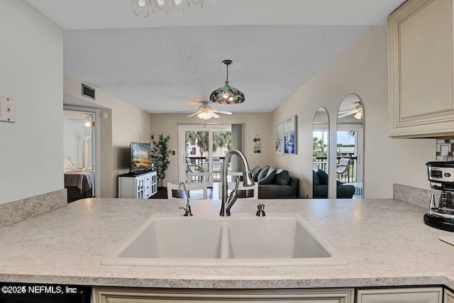 kitchen featuring visible vents, open floor plan, light countertops, a textured ceiling, and a sink