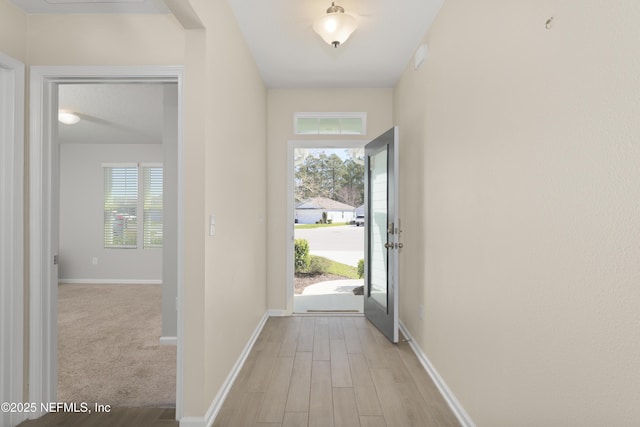 foyer entrance with baseboards and light wood finished floors