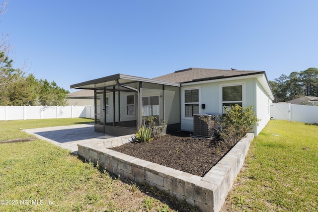 back of property with a lawn, cooling unit, a fenced backyard, and a sunroom