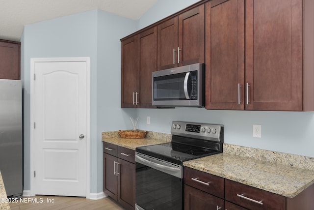 kitchen featuring appliances with stainless steel finishes, light wood-type flooring, baseboards, and light stone countertops