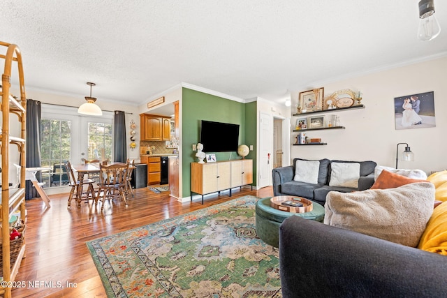 living area with a textured ceiling, wood finished floors, and crown molding