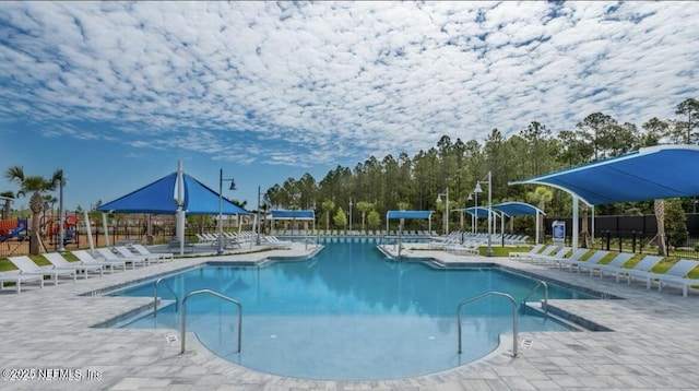 community pool with fence and a patio