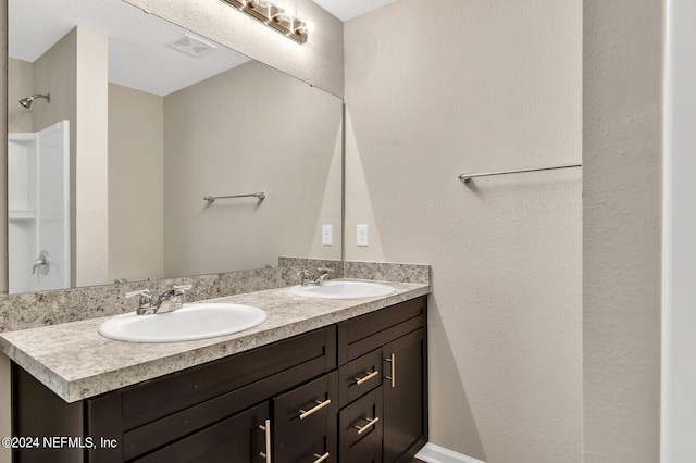 full bathroom featuring double vanity, visible vents, and a sink