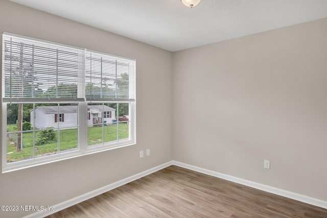 unfurnished room featuring baseboards and wood finished floors