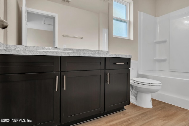 bathroom featuring toilet, wood finished floors, visible vents, vanity, and washtub / shower combination