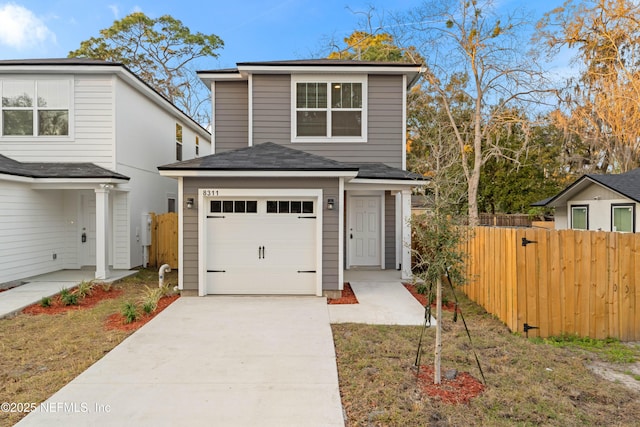 traditional-style home with a garage, fence, and concrete driveway