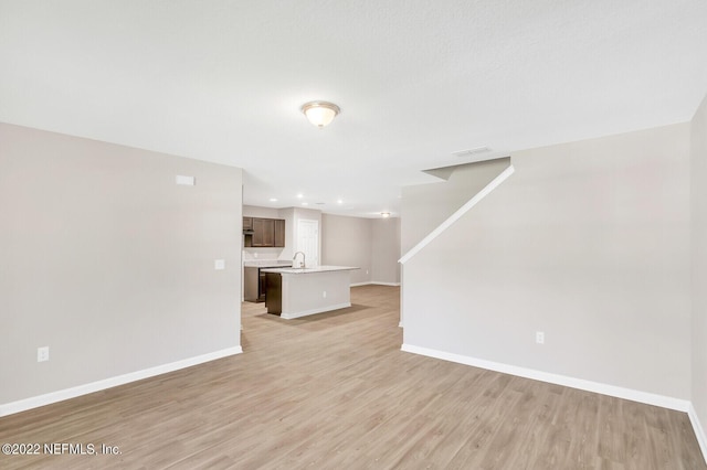 unfurnished living room featuring light wood-type flooring, visible vents, baseboards, and recessed lighting