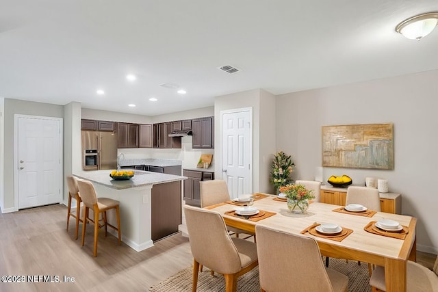 dining room with light wood-style floors, visible vents, baseboards, and recessed lighting