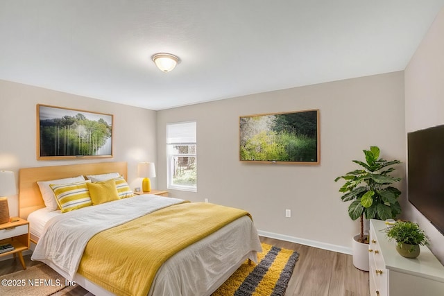 bedroom with baseboards and wood finished floors