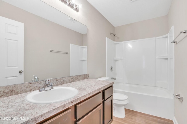 bathroom featuring  shower combination, vanity, toilet, and wood finished floors