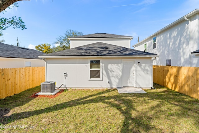 back of property with a lawn, cooling unit, and a fenced backyard