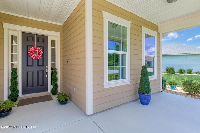 view of exterior entry featuring covered porch