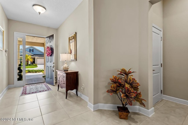 entryway with baseboards and light tile patterned floors