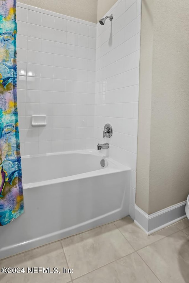 bathroom with baseboards, shower / bath combination with curtain, and tile patterned floors