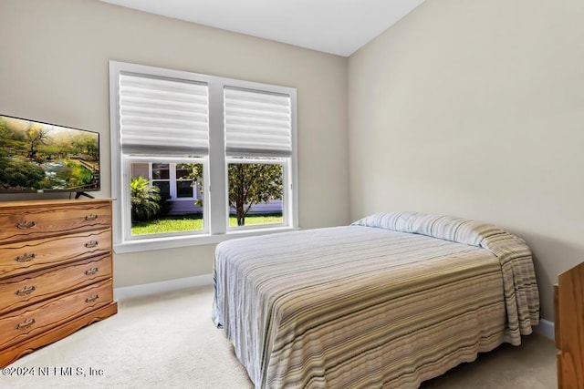 bedroom featuring baseboards and light colored carpet