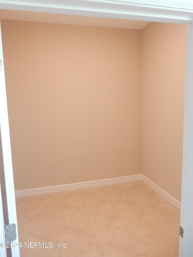 unfurnished room with light tile patterned floors and baseboards