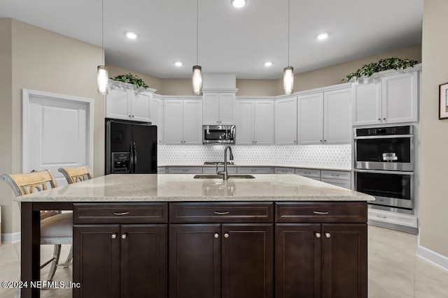 kitchen with white cabinets, dark brown cabinetry, stainless steel appliances, and a sink