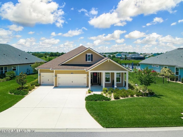 view of front of property with concrete driveway, roof with shingles, an attached garage, fence, and a front lawn