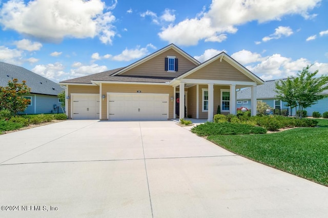 view of front of property featuring a garage, driveway, and a front lawn