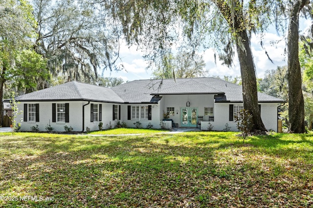 rear view of property with a yard, french doors, and brick siding